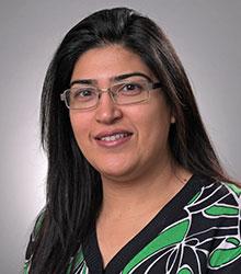 Dr. Rabia Shahbaz wearing glasses and smiling at camera
