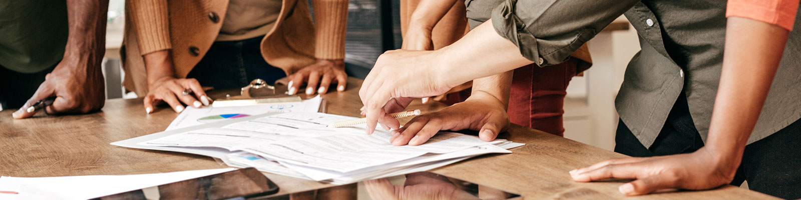 Group of students collaborating over documents on table
