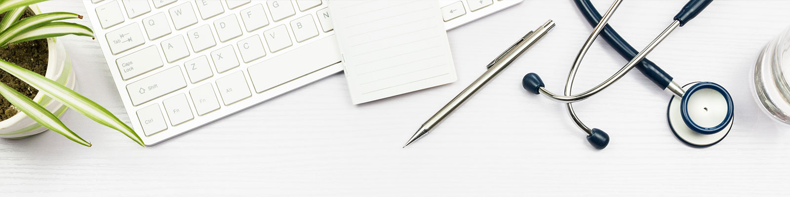 hero_shs_stethoscope-plant_1600x400.jpg desktop with plant, computer keyboard, stethoscope, pen