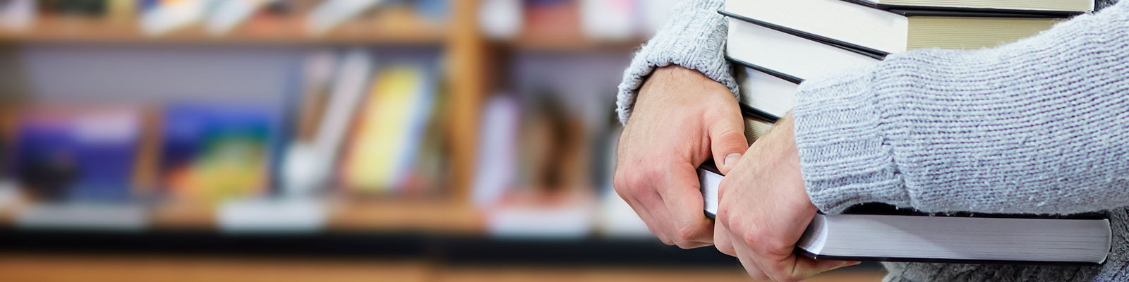 person in sweater carrying books