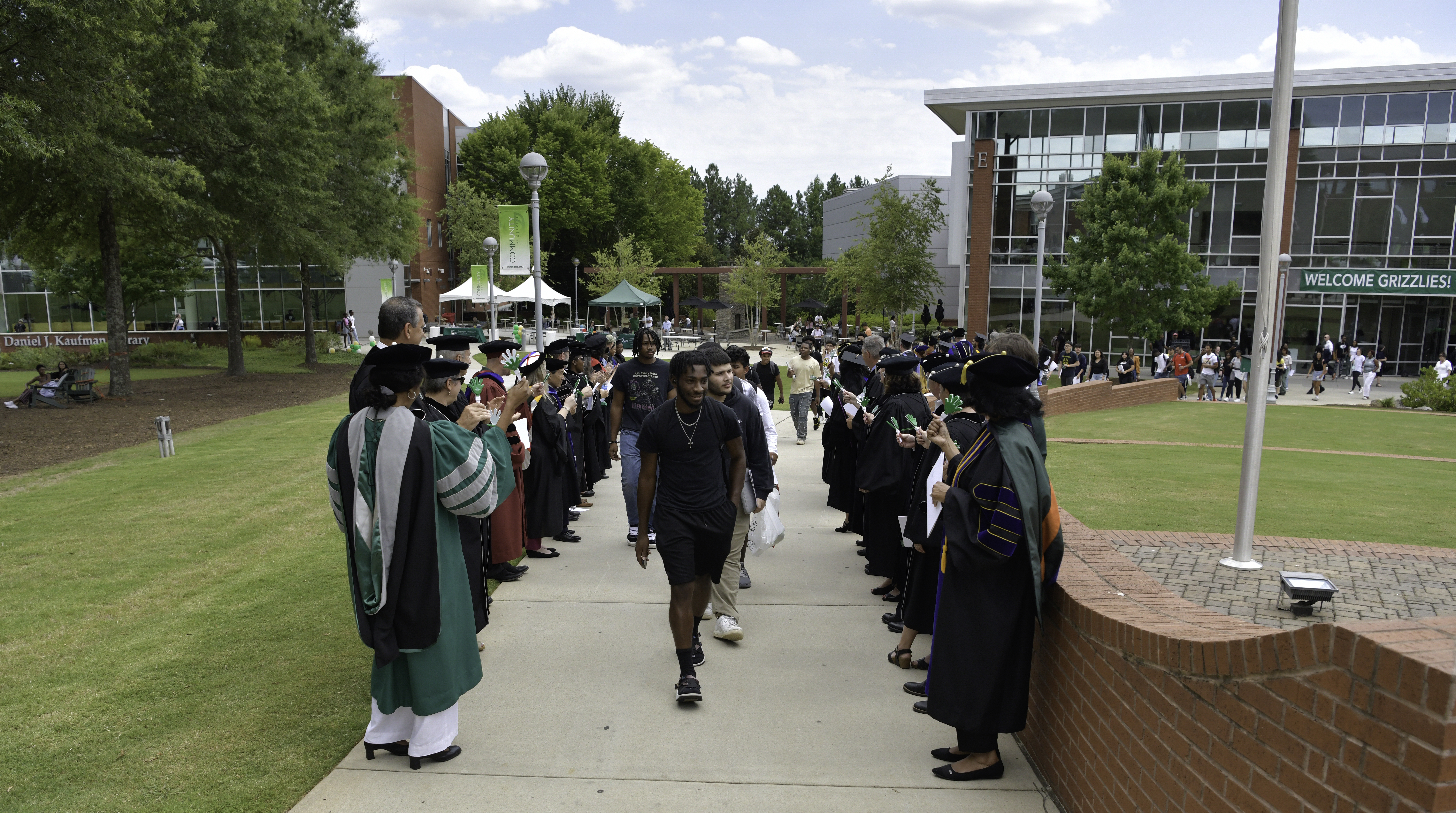 Freshman walking through two lines of greeting faculty at 2024 First-Year Convocation Ceremony