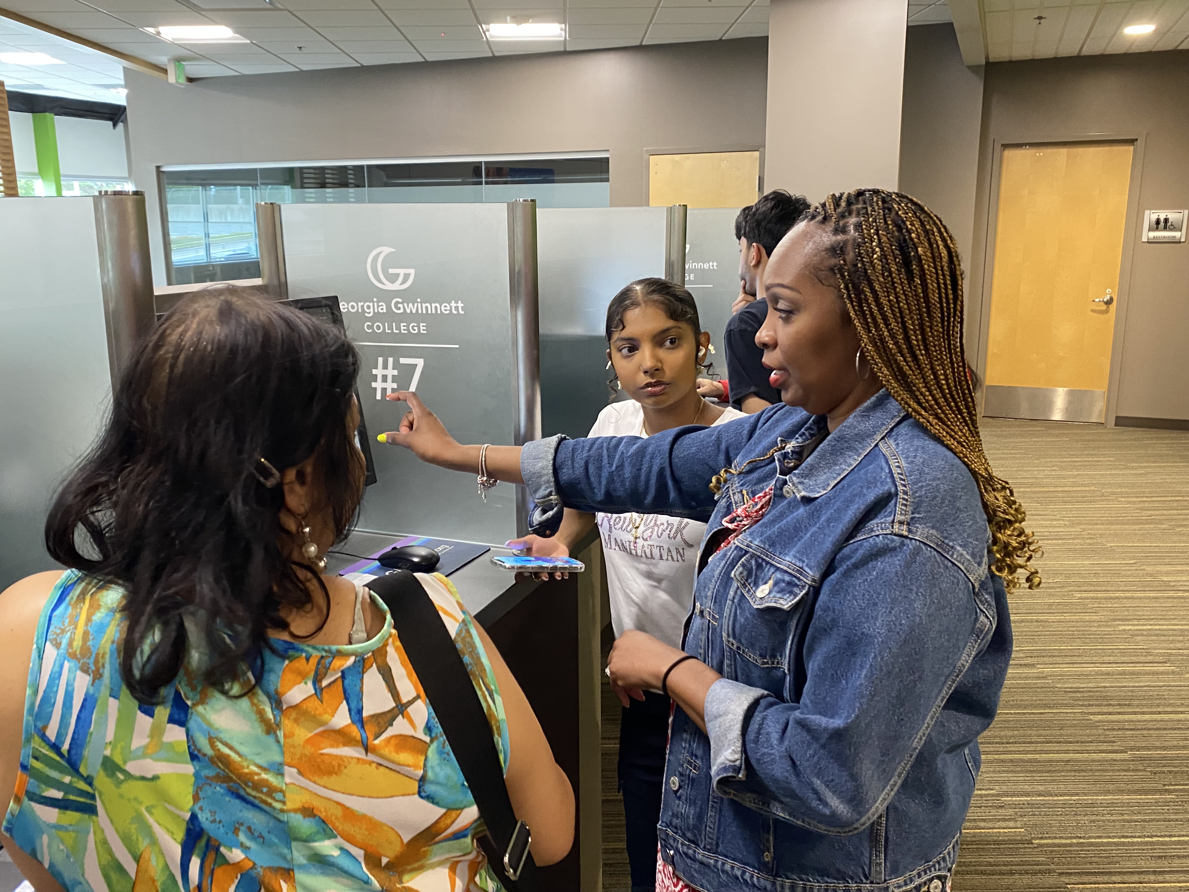 Parent and student standing next to a financial aid counselor.
