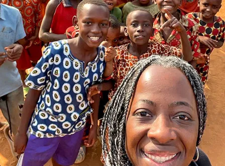 Dr. Margie Gill posing with school children in Africa