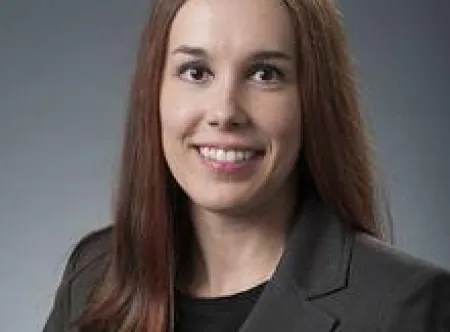 Dr. Reanna Berry wearing gray jacket and black shirt smiling at camera
