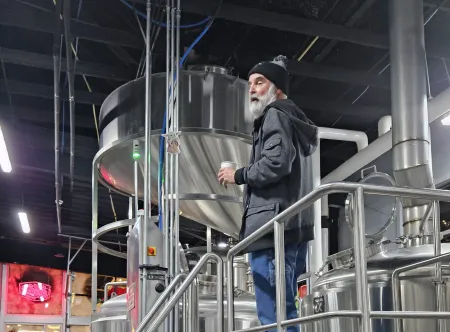 StillFire Brewing owner, Phil Farrell on the catwalk between the fermentation vessels.