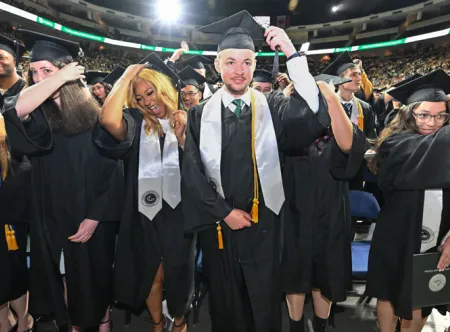 Male and female students turning the tassels on their graduation caps