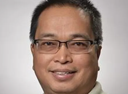 Dr. Melchor C. de Guzman smiling at camera