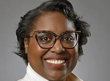 Dr. Alesha Harris wearing glasses and smiling at camera