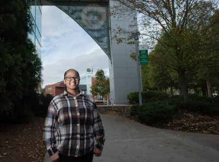 Nia Mallory posing near the Arch of Knowledge and library