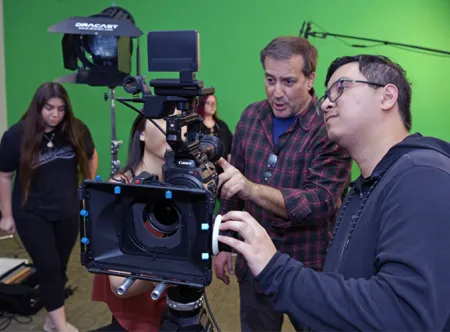 Students looking at film camera