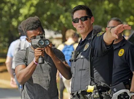 A police officer showing a student how to use a radar device