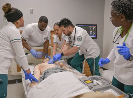 Nursing students practicing CPR on a mannequin
