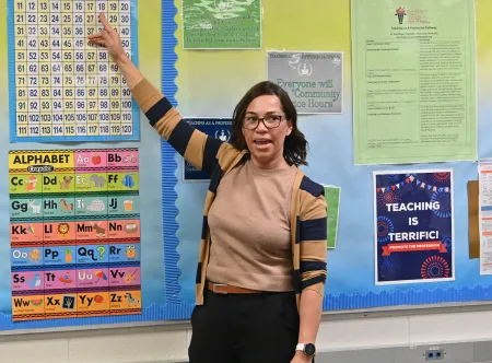 Teacher pointing to a poster on the wall
