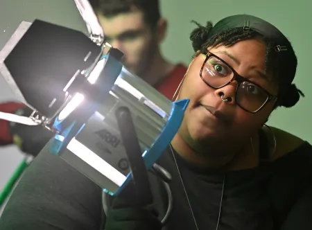 Student setting up a film light