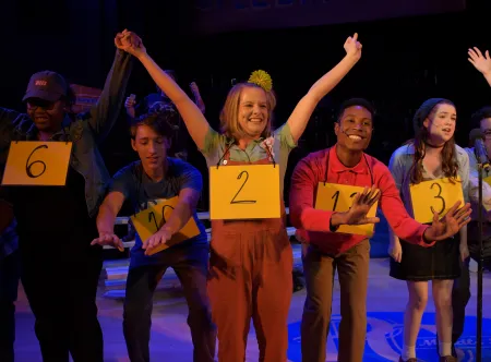 Students singing in a play on stage