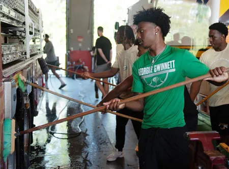 Mario Hill and the Georgia Gwinnett College men’s basketball team visited the Gwinnett County Fire and Emergency Services Station 31 to learn about firefighting and to wash the station’s ladder truck.