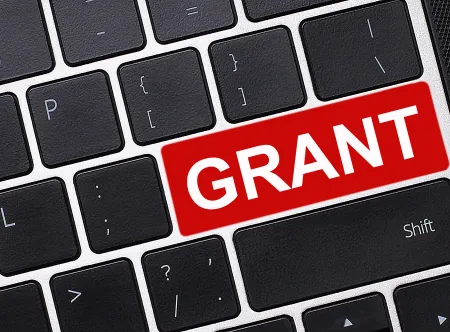 An image of a keyboard with black keys and a red "GRANTS" key