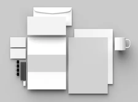 Black and white image of envelops, business cards, stationery and cup