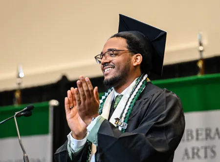 Nolberto Sanchez standing at podium as speaker for spring 2025 commencement ceremony