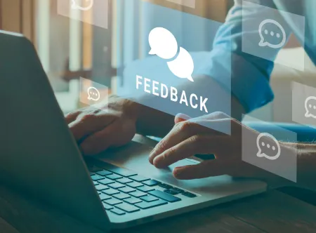 Man typing on computer keyboard with images of silhouettes of feedback and quotation bubbles