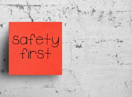 safety first written on an reddish orange Sticky Note