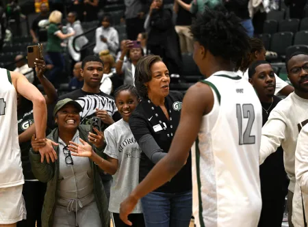 President Jann L. Joseph celebrates along with other GGC basketball fans after a winning basketball game.