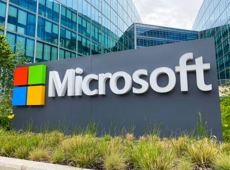 Getty Images Microsoft logo with four red and green square boxes stacked above blue and yellow boxes and "Microsoft" written in white letters on the left side on signage outside a glass building