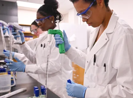 Three women working in a biology lab