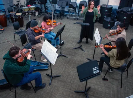 A professor directs six students in a music ensemble class