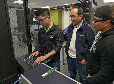 IT faculty member monitoring students working in the server room