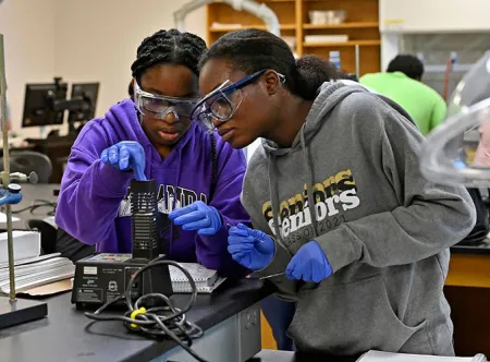 Two engaged students conducting experiment in lab