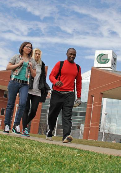 Students walking across campus with signature Portman building in background