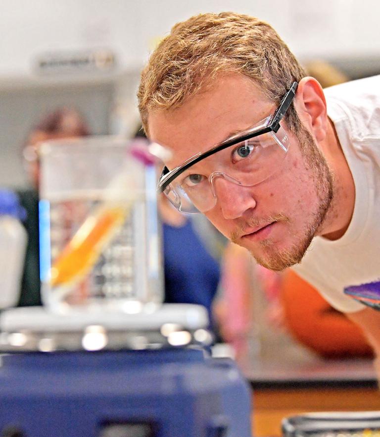 Chemistry student examining beaker