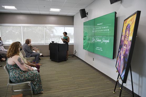 People listening to a female presenter in The Joseph Family Presentation Room