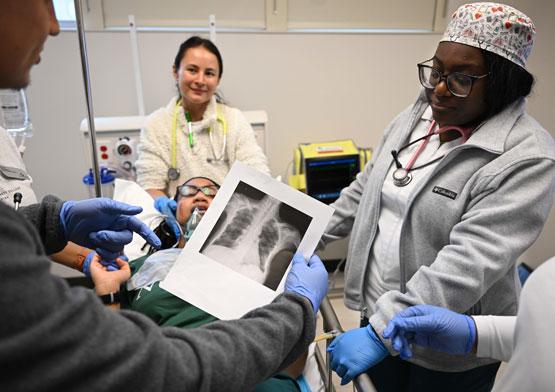 Students Hugo Torres, Allison Strickland, Chelsi Bolanos, Trinity Strickland and Bidjemia Ndifon read Raina Emerson's x-rays while participating in Emergency Day