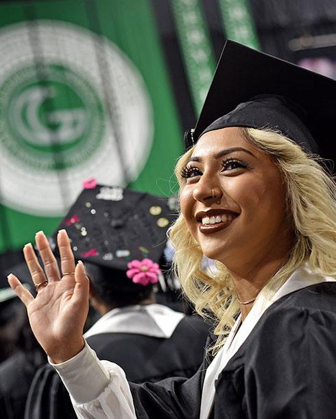 Graduate waving at commencement