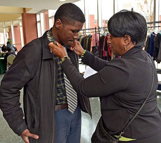 Career Services staff assisting student with business attire in the Career Lending Closet