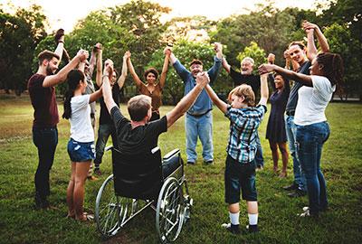 diverse set of people in circle holding raised hands