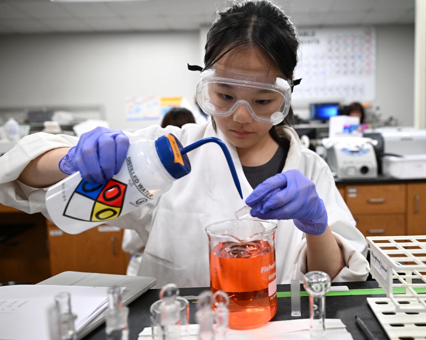 Student Elisha Yoon prepares a stock solution of Red #40 dye.