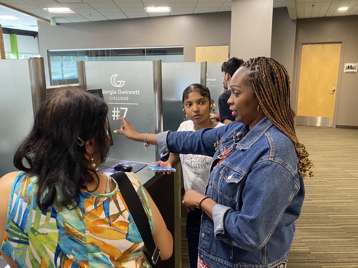 Parent and student standing next to a financial aid counselor.