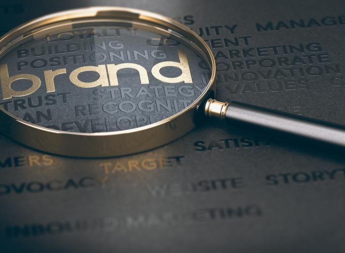the word brand magnified by a gold and black magnifying glass