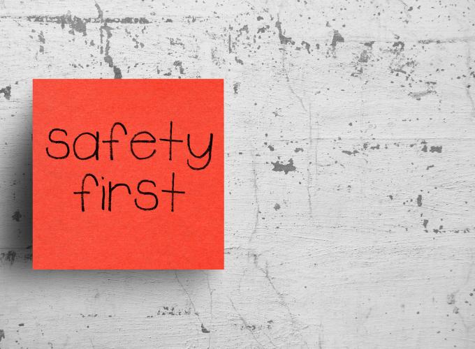 safety first written on an reddish orange Sticky Note