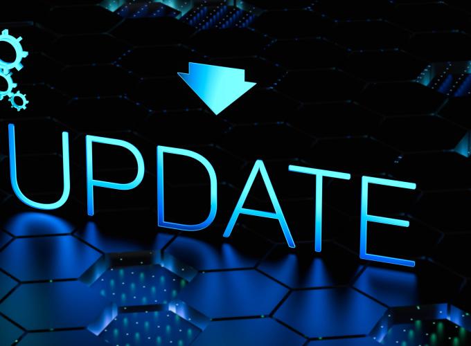 The word "Update" written in irridacent blue with a download arrow above and cyberspace