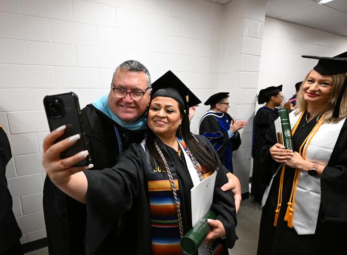 Dr. Matthew Bogan, (left) professor of special education and special education and social foundations chair in the School of Education, poses with the school’s graduates during the May 2025 commencement ceremony. 