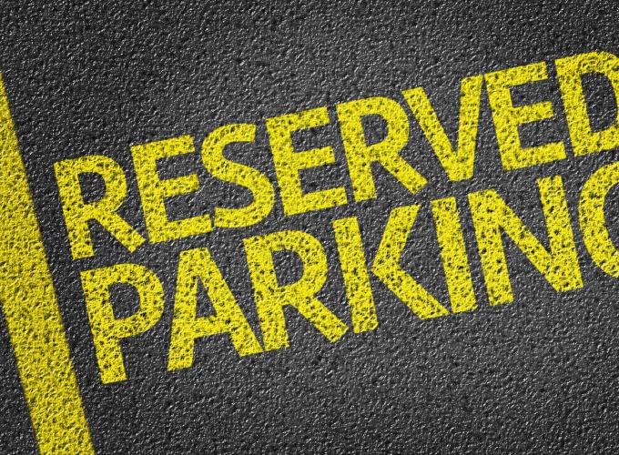 Reserved parking written in yellow on asphalt