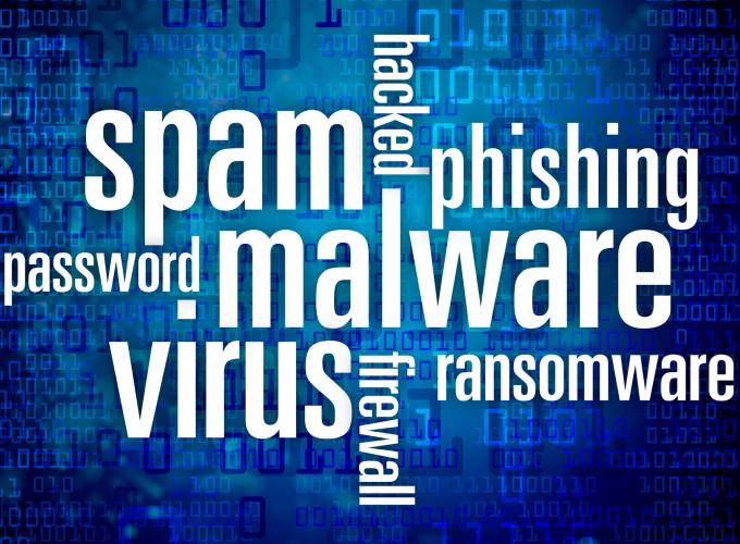 Getty Image of a blue background word cloud and white lettering "spam," "phishing," "password," "malware," "virus," "ransomware," "hacked," and "firewall"
