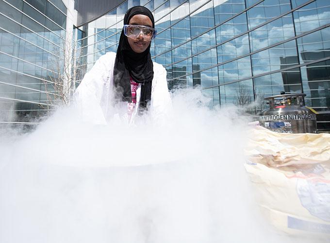 Maa'idah Abukar makes ice cream with liquid nitrogen for families during the Atlanta Science Festival’s “GGC Grizzlies in the Forest of Science,”