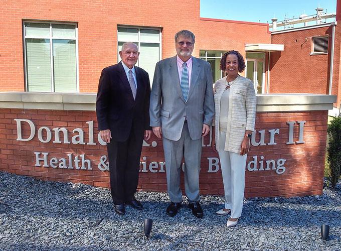 Sonny Perdue, Donald K. Balfour II, Jann L. Joseph posing in from of the newly named Donald K. Balfour II Health and Sciences Building