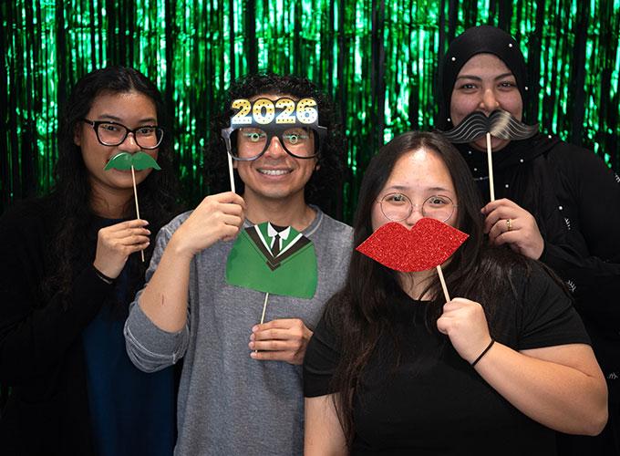 Seniors posing with fake mustaches in photobooth