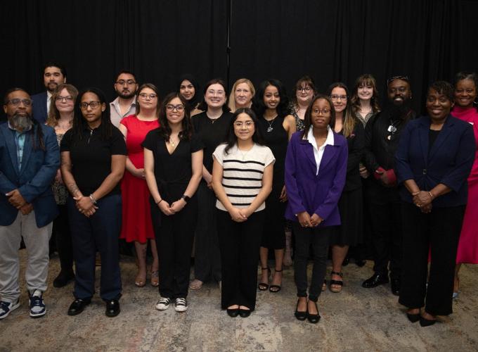A group photo of 19 people dressed in business attire and posing for the picture